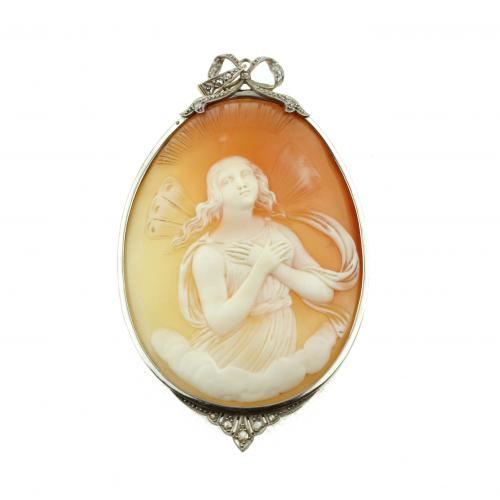 Carved shell representing a winged nymph, mounted on yellow gold and platinum, surrounded by rose-cut diamonds.7x4,5 cm. 18,2 gr.