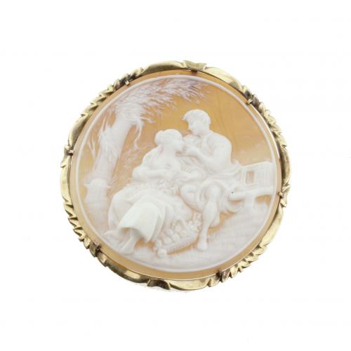 Carved shell with lover's scene. Gold rim 14 kt. 5 cm. diam. 11,4 gr. 