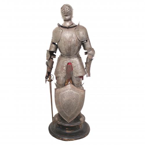 Chiselled metal, mail skirt, shield and sword. Includes a wooden pedestal.175 cms. high without pedestal. Total 205 cms. 