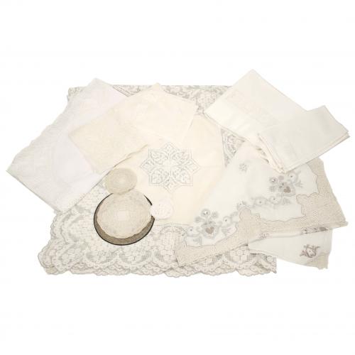 Set of three tablecloths and napkins, two large tablecloths, doilys and coasters.In linen, cotton and silk gauze. Hand embroidered lace, one tablecloth fully embroidered.430 x 220 cm. largest tablecloth. 9,5 cm. diam. smallest coaster