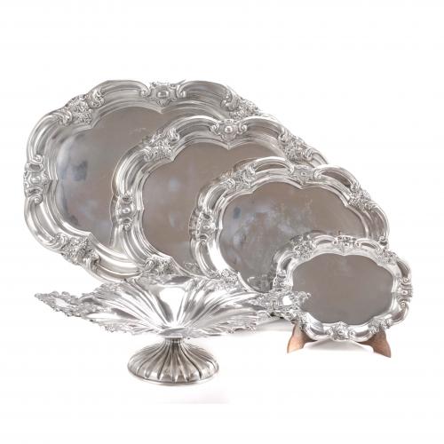 Hallmarked. Trays by A. Pallé and centerpiece by Domenech Soler Cabot.Four oval trays 50x36 cm., 41x32 cm., 34x27 cm., 24x18 cm.Centerpiece with handles 13x44x31 cm.4.052 gr.