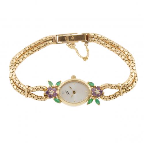 Gold with emeralds, amethysts and diamonds forming flowers around the case. Safety chain. Quartz clock. 22,9 gr.