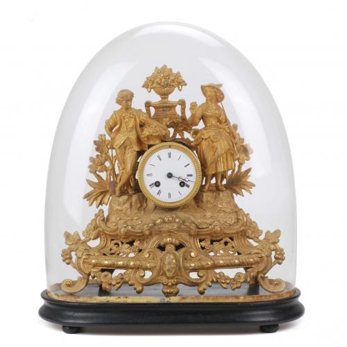 Clock decorated with pastoral scene in gilt calamine; glass bell and wooden pedestal. París clockwork. In good working order.With key and pendulum. 35 x 36 x 13 cm. clock. 