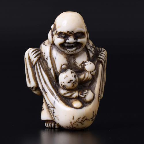 JAPANESE SCHOOL. MEIJI PERIOD, 19TH CENTURY. "HOTEI, ONE OF THE SEVEN GODS OF FORTUNE, CARRYING A CHILD IN HIS SACK".