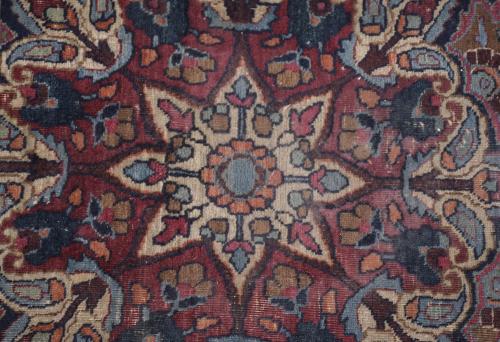 PERSIAN CARPET IN REDDISH AND BLUISH TONES.