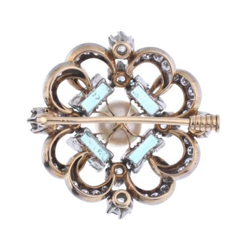 Brooch with diamonds, emeralds and a central pearl.