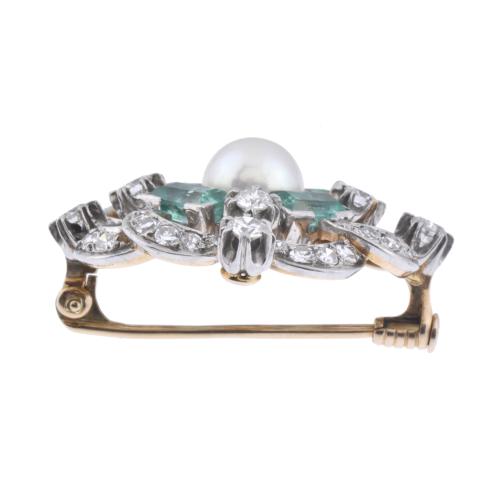 Brooch with diamonds, emeralds and a central pearl.